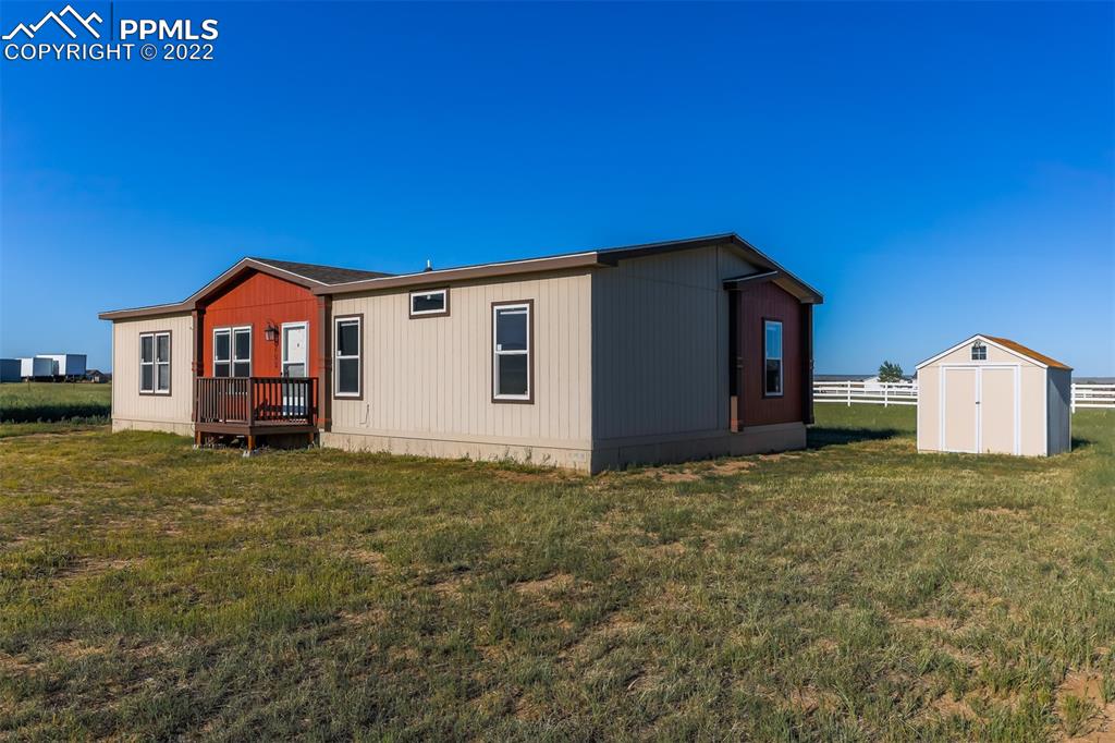 703 Buffalo Run Road Calhan, CO 80808 - Photo 2 of 25 a big house with a big yard and large trees