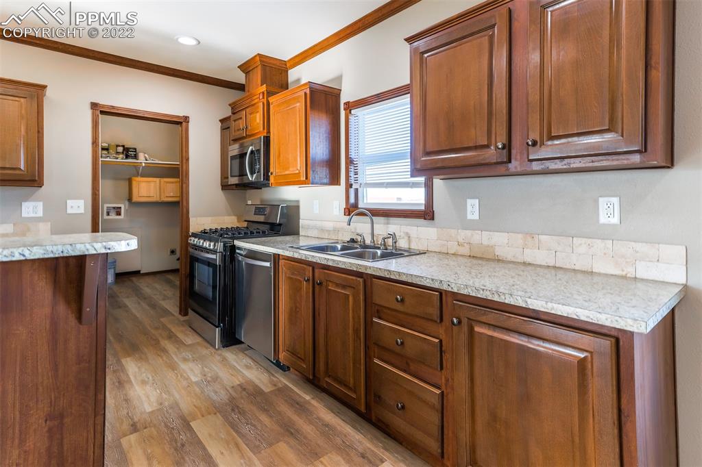 703 Buffalo Run Road Calhan, CO 80808 - Photo 10 of 25 a kitchen with stainless steel appliances granite countertop a sink stove and cabinets