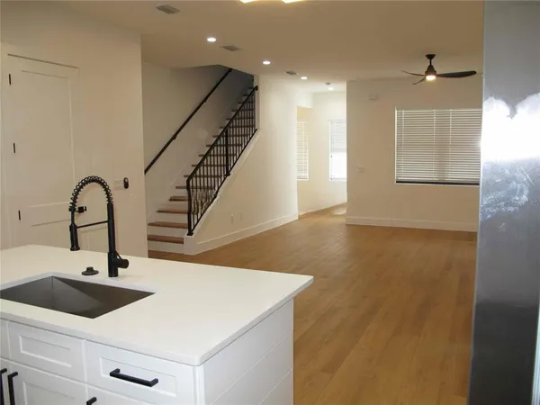 a kitchen with kitchen island a sink and wooden floor