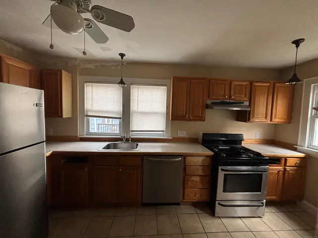 a kitchen with stainless steel appliances a stove a sink and a refrigerator