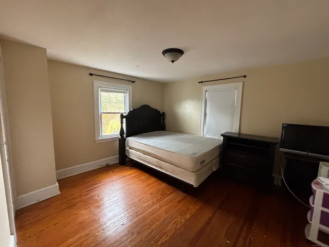 a bedroom with a bed and wooden floor