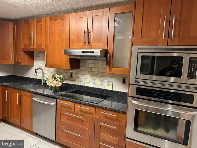 a kitchen with granite countertop cabinets stainless steel appliances and a sink