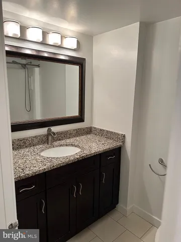 a bathroom with a granite countertop sink and a mirror