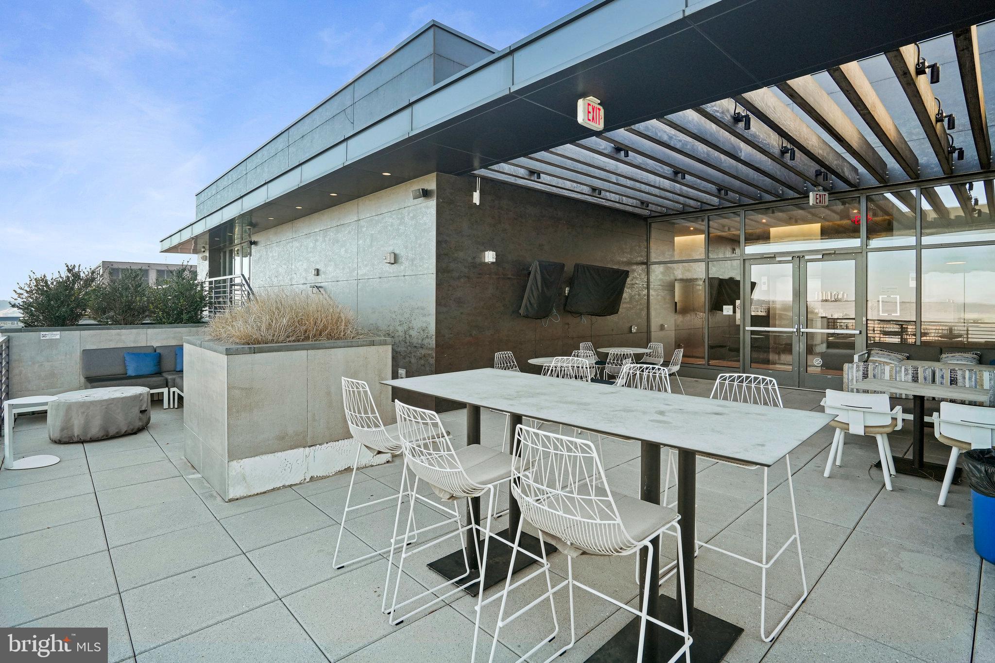1211 Van Street Southeast, Unit 501 Washington, DC 20003 - Photo 19 of 37 a view of a patio with table and chairs potted plants and floor to ceiling window