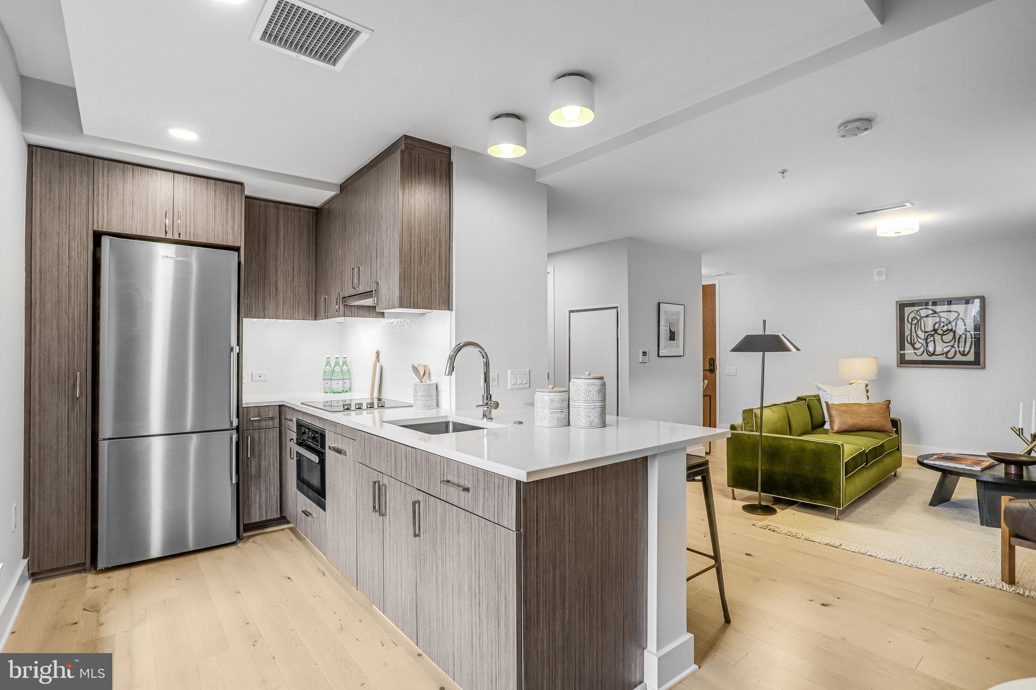 1211 Van Street Southeast, Unit 501 Washington, DC 20003 - Photo 4 of 37 a kitchen with granite countertop a refrigerator and a sink