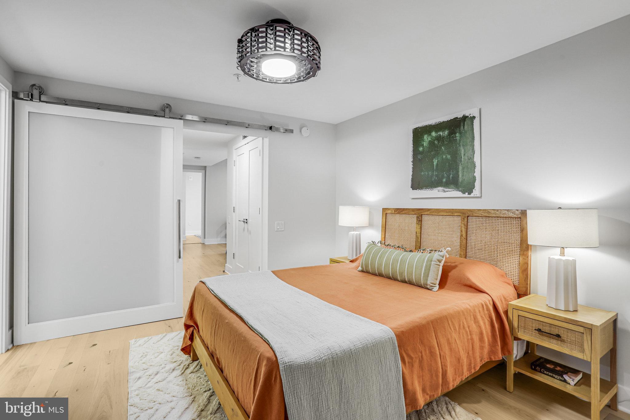 1211 Van Street Southeast, Unit 501 Washington, DC 20003 - Photo 10 of 37 a bedroom with a bed and a chandelier