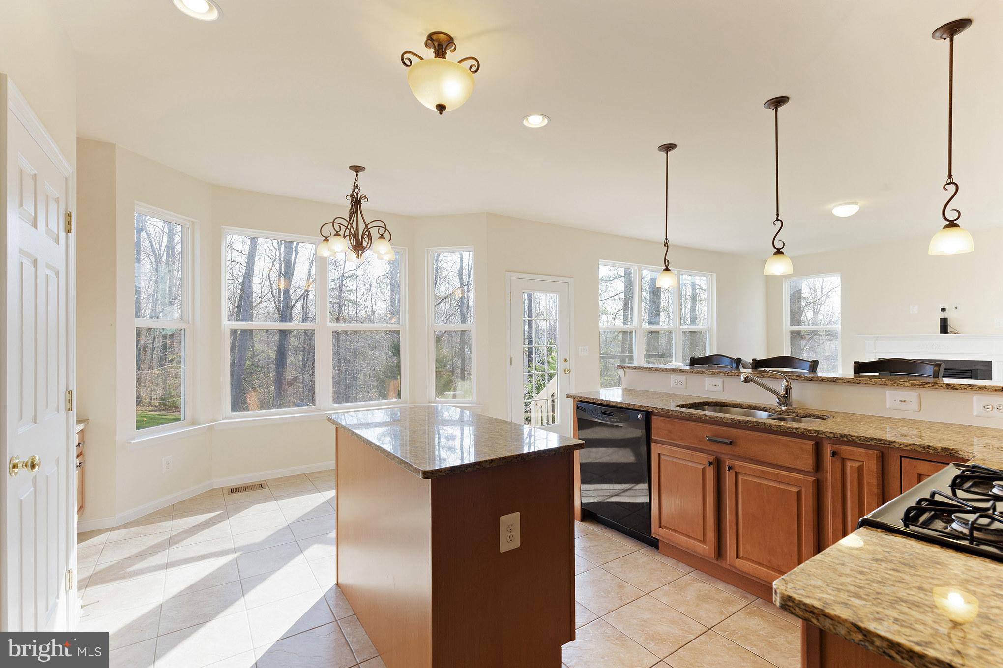 2035 Baythorne Road Prince Frederick, MD 20678 - Photo 8 of 30 a large kitchen with kitchen island a large counter top space a sink stainless steel appliances and cabinets