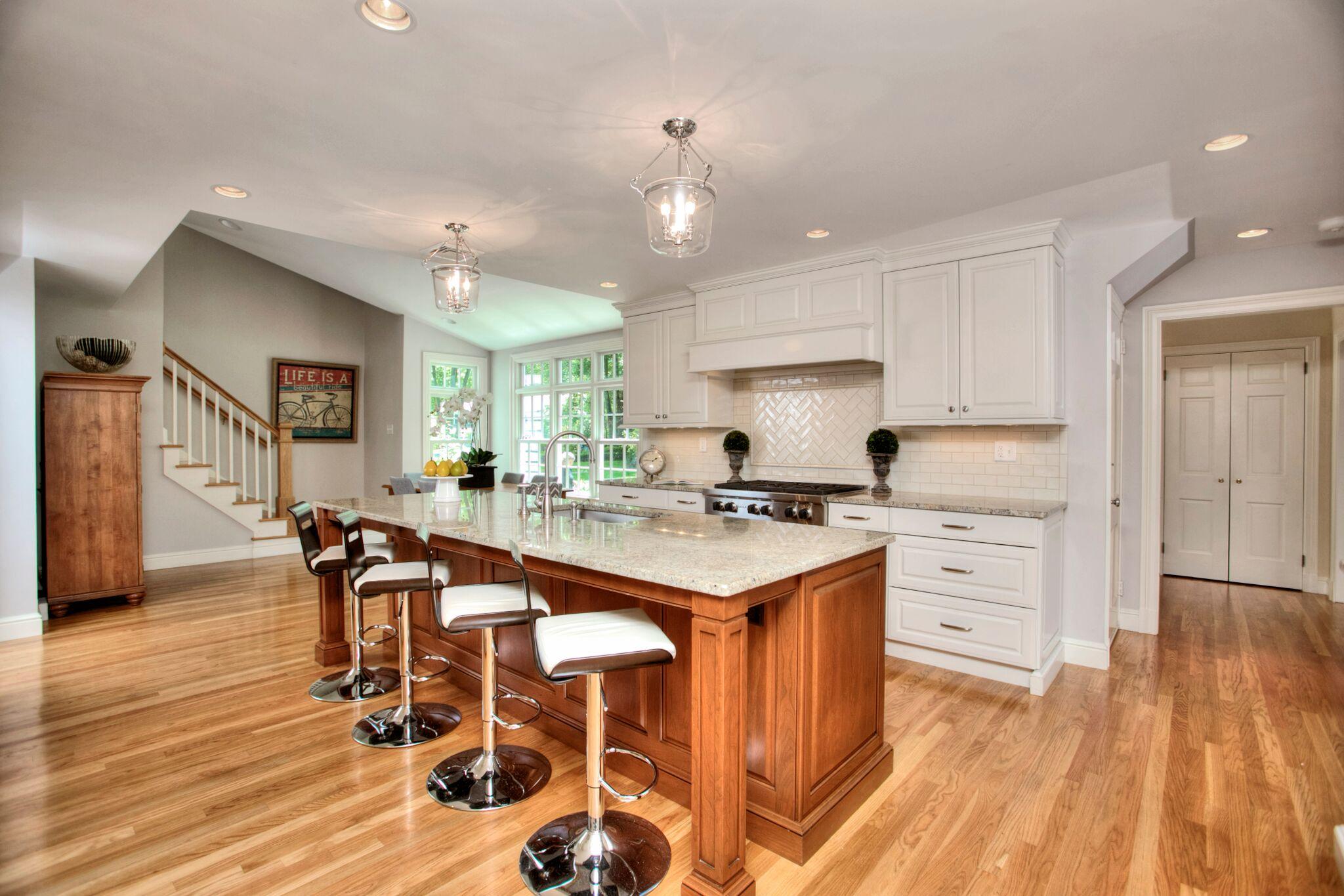 5 Haskell Lane Darien, CT 06820 - Photo 10 of 22 a large kitchen with kitchen island a island a stove a dining table and chairs with wooden floor