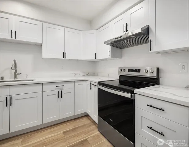 a kitchen with stainless steel appliances granite countertop white cabinets a sink and dishwasher