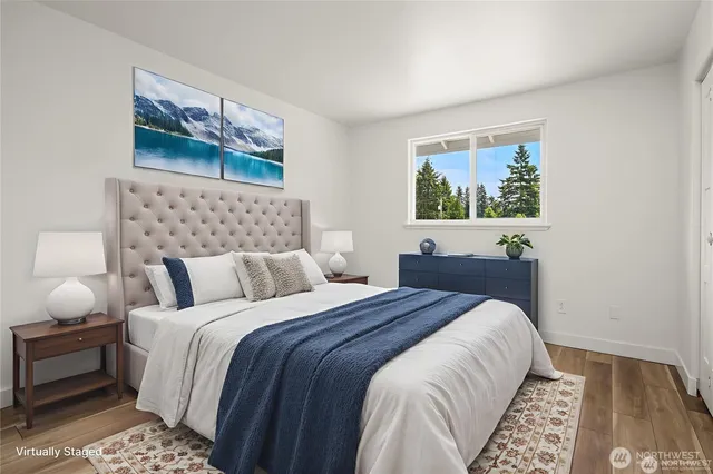 a bed room with a bed and a painting on the wall