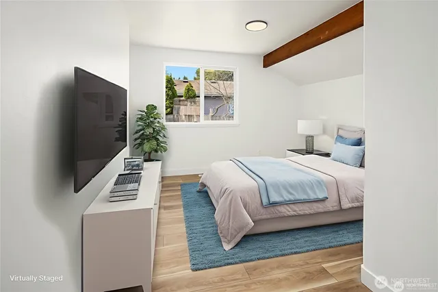 a bedroom with a flat screen tv a lamp and a bed