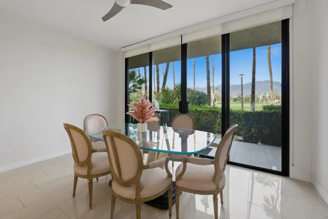 a dining room with furniture a chandelier and glass door