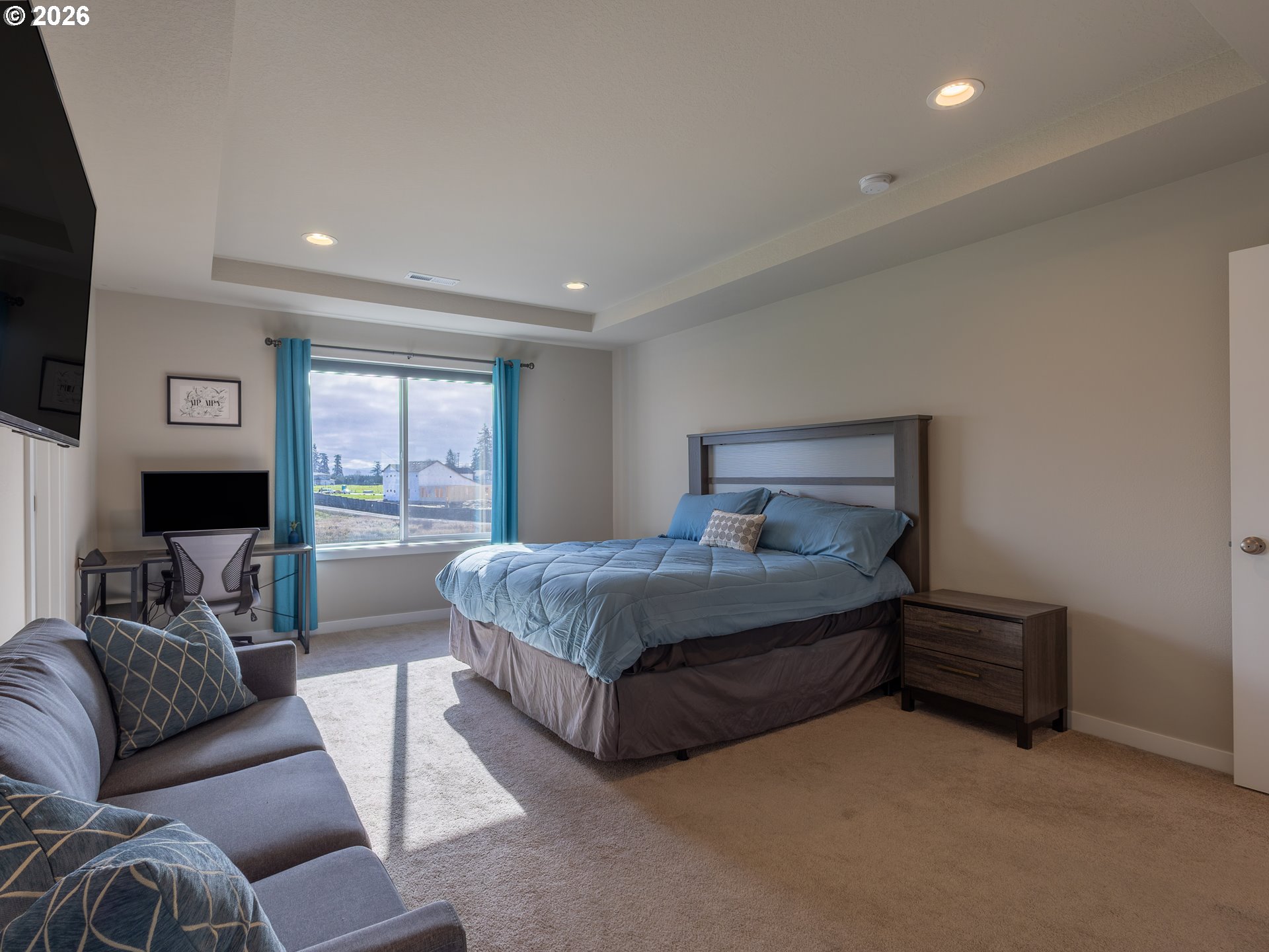 8827 North 1st Circle Ridgefield, WA 98642 - Photo 18 of 38 a spacious bedroom with a bed a couch and a flat screen tv