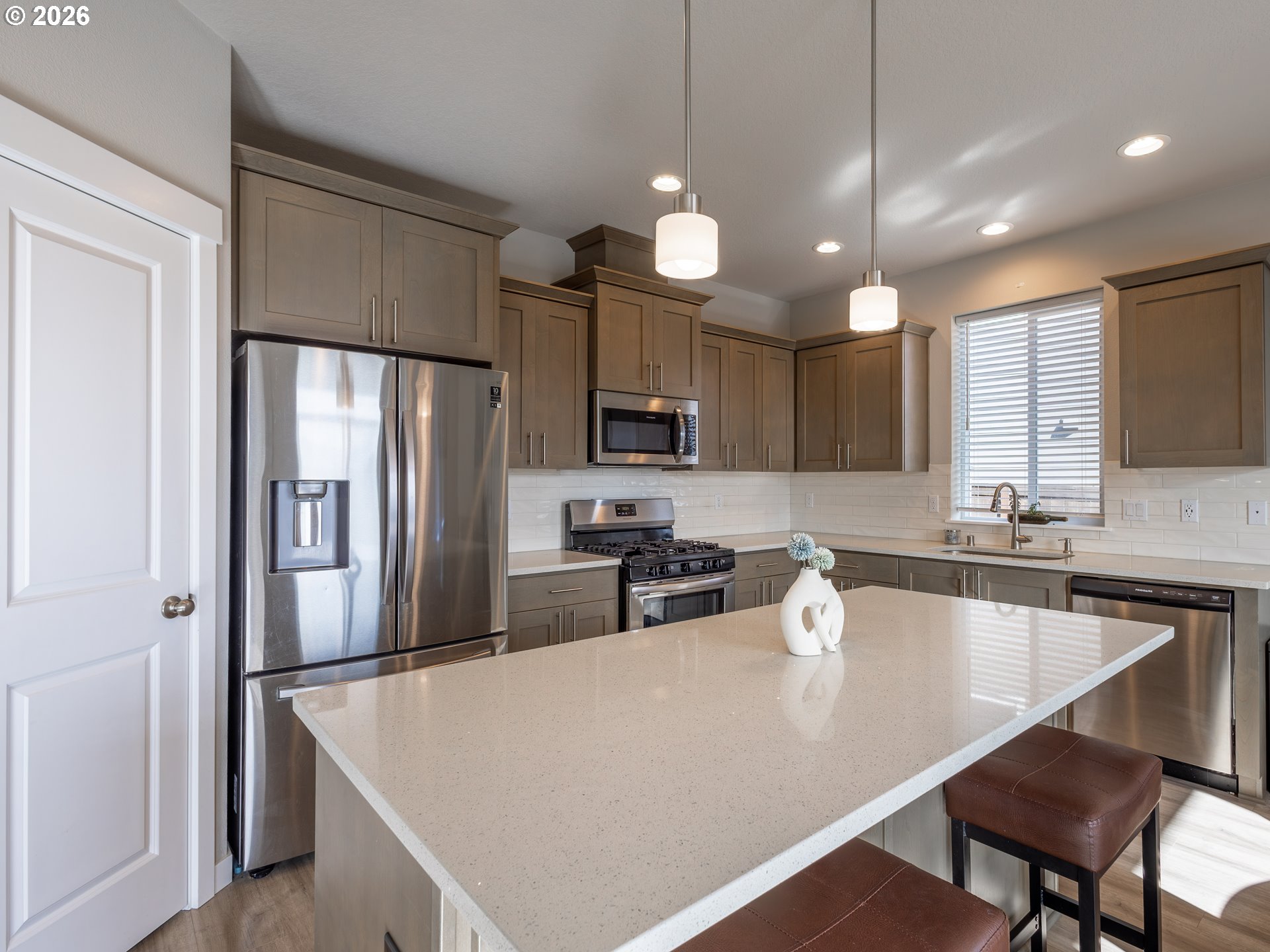 8827 North 1st Circle Ridgefield, WA 98642 - Photo 9 of 38 a kitchen with stainless steel appliances a refrigerator a sink a center island a stove and a sink