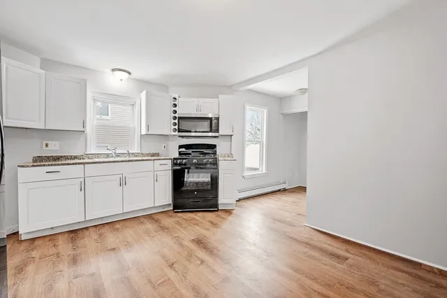 a kitchen with wooden floors and white appliances