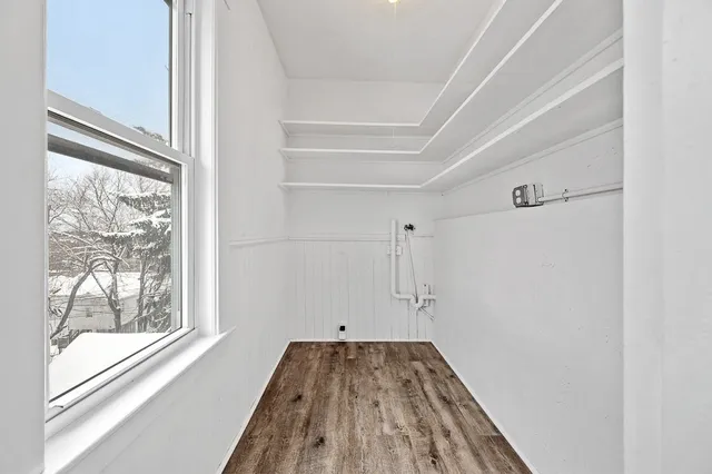 a view of a bedroom with wooden floor and windows
