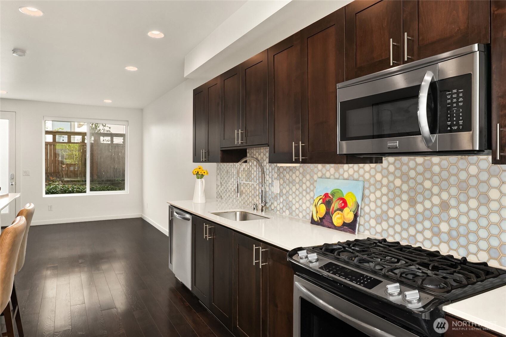 3631 Courtland Place South, Unit B Seattle, WA 98144 - Photo 12 of 27 a kitchen with stainless steel appliances a stove a microwave cabinets and wooden floor