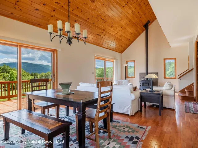a dining room with wooden floor a chandelier a wooden table and chairs