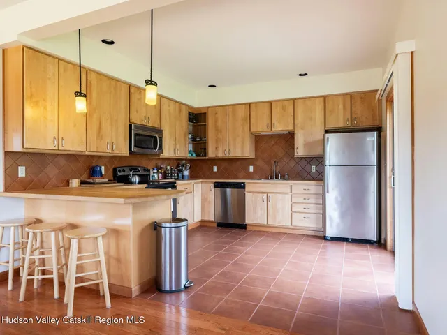 a kitchen with stainless steel appliances granite countertop a refrigerator a stove a sink and white cabinets