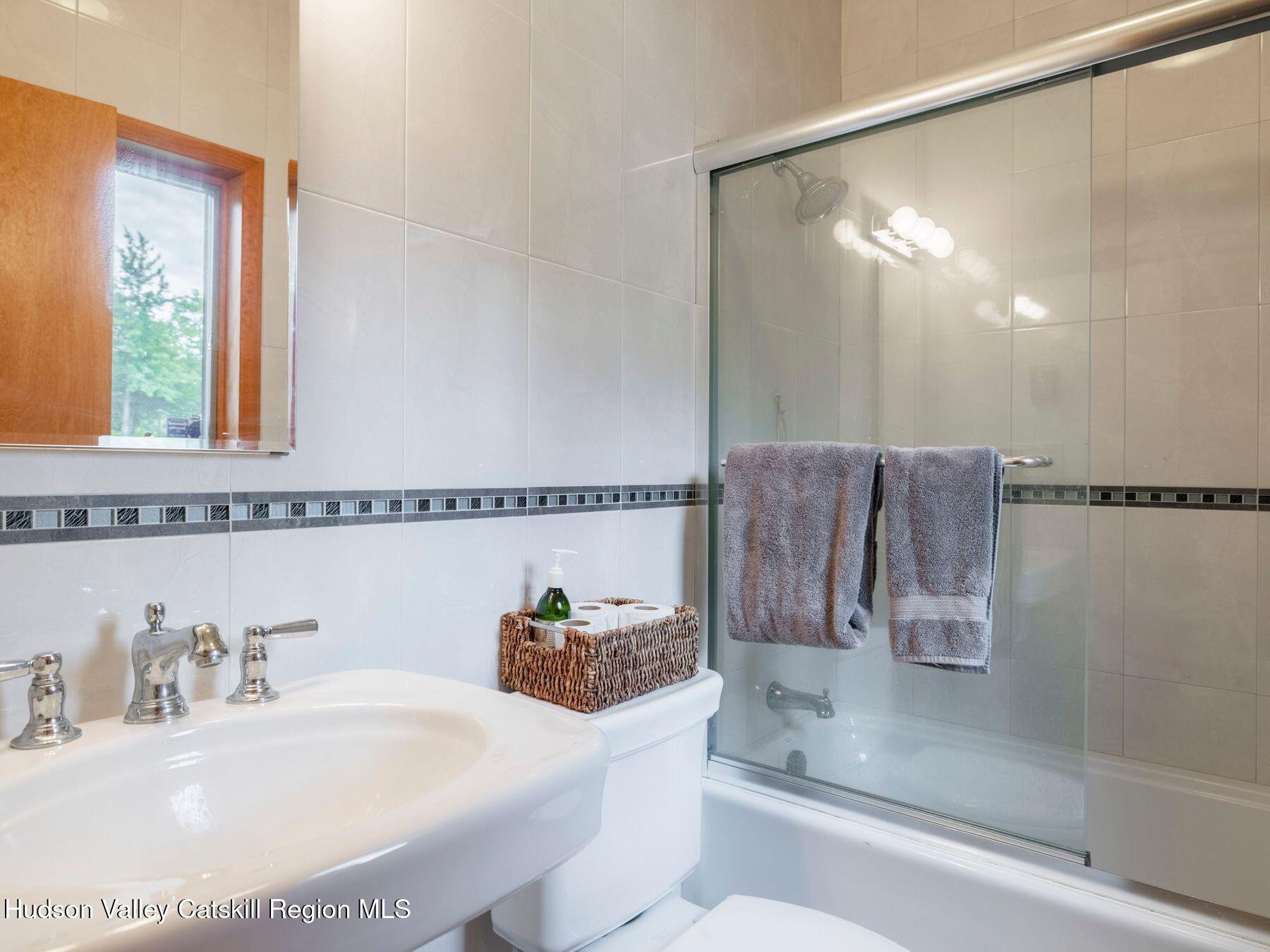5147 Rte 23c Jewett, NY 12444 - Photo 26 of 54 a bathroom with a granite countertop sink a mirror and shower