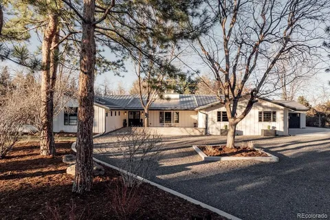 a front view of a house with yard and trees