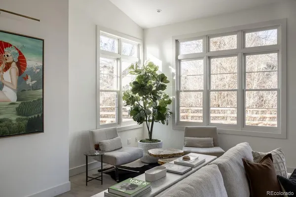 a living room with furniture and wall paintings