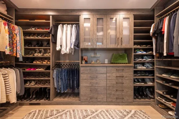 a view of walk in closet with clothes and shoes