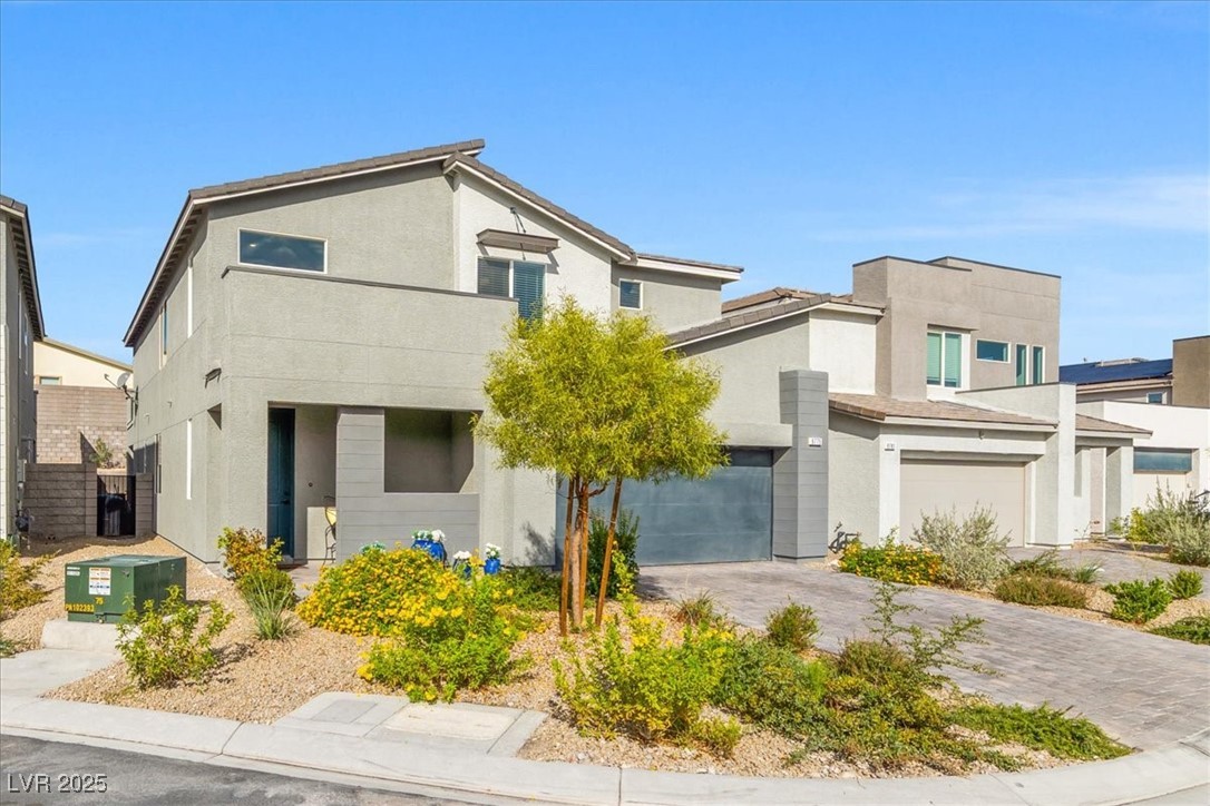 9775 Free Rappel Avenue Las Vegas, NV 89166 - Photo 4 of 51 Contemporary house featuring stucco siding and driveway