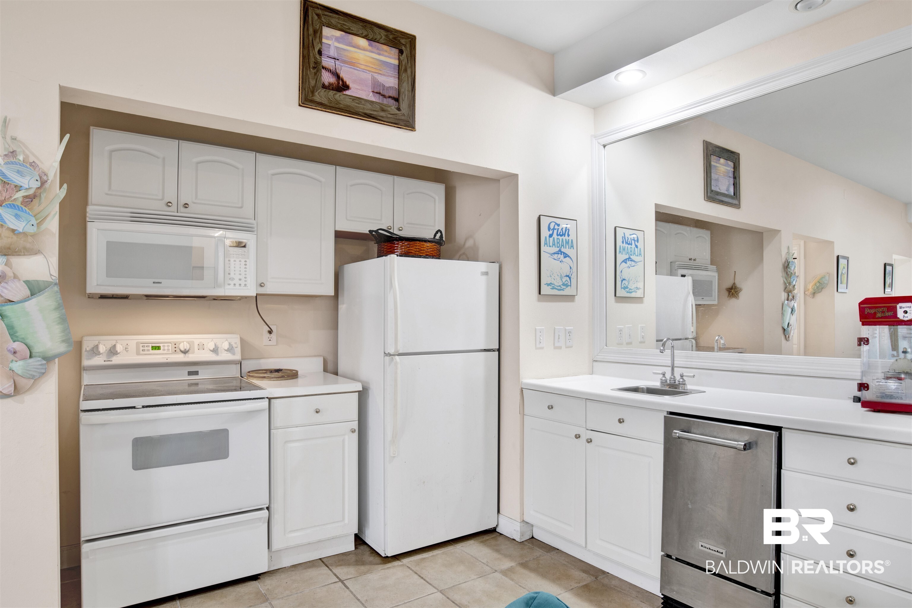 33093 River Road Orange Beach, AL 36561 - Photo 21 of 30 Kitchen with sink, white appliances, light tile patterned floors, and white cabinets