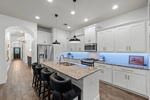a kitchen with stainless steel appliances granite countertop a sink stove and refrigerator