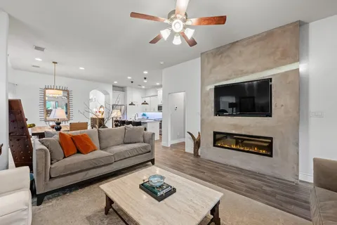 a kitchen with stainless steel appliances granite countertop a stove a refrigerator a sink a dining table and chairs with wooden floor