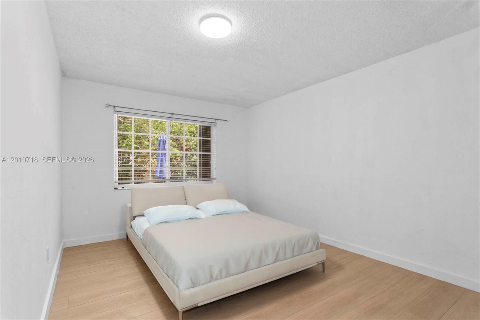 9125 Carlyle Avenue Surfside, FL 33154 - Photo 12 of 18 a bedroom with a bed and a window