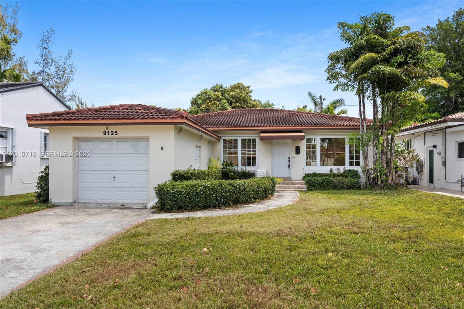 9125 Carlyle Avenue Surfside, FL 33154 - Photo 2 of 18 a front view of a house with a garden