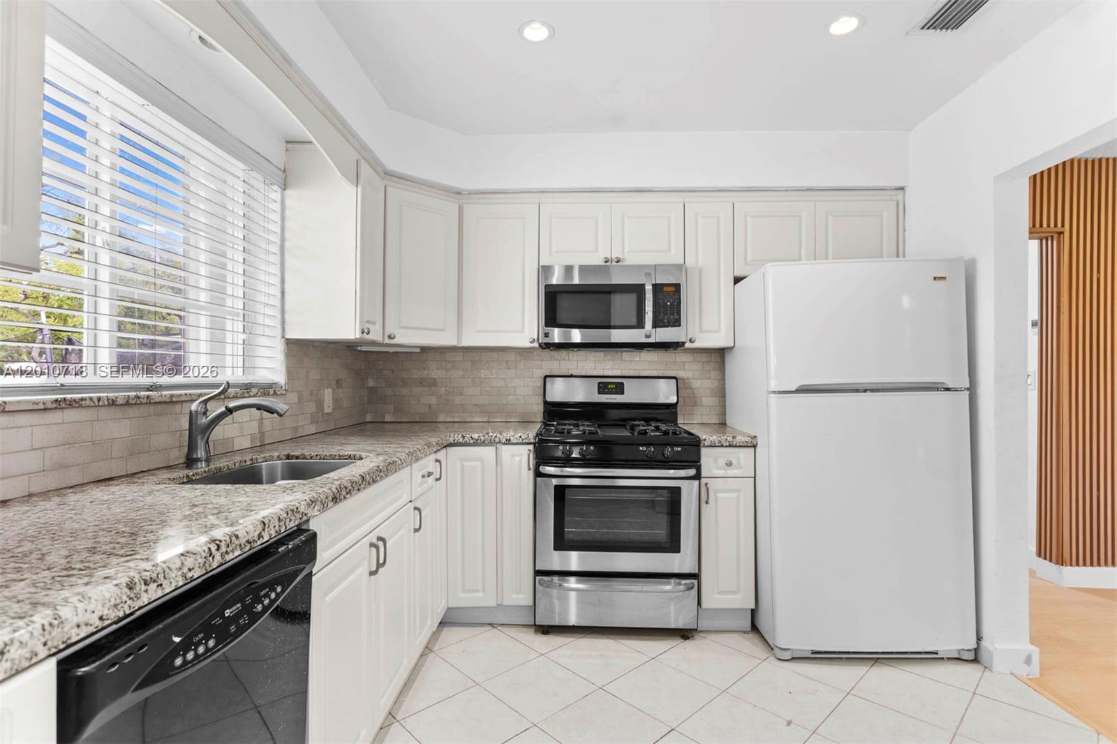 9125 Carlyle Avenue Surfside, FL 33154 - Photo 6 of 18 a kitchen with granite countertop a refrigerator stove and sink