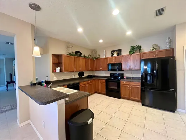 a kitchen with stainless steel appliances kitchen island granite countertop a sink counter space and cabinets