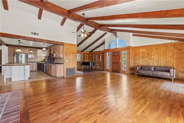 a view of a livingroom with furniture a fireplace wooden floor and staircase