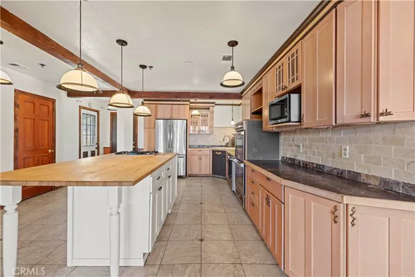 a kitchen with stainless steel appliances granite countertop a stove a sink and a refrigerator
