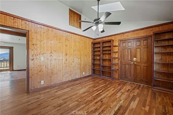 a view of an empty room with window and wooden floor