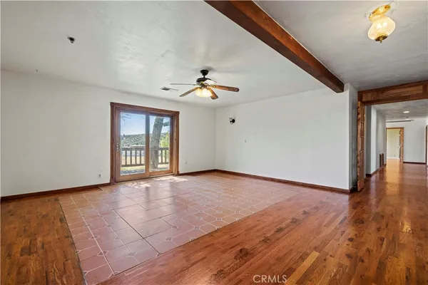 a view of a big room with wooden floor and windows