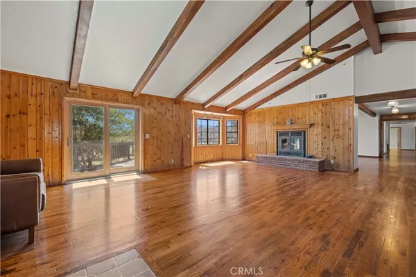a view of empty room with wooden floor and windows