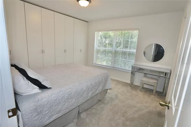 a bedroom with a bed and a flat tv screen on the wall