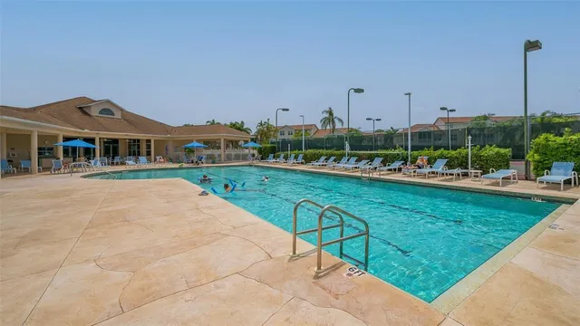 a view of swimming pool with a yard and palm trees
