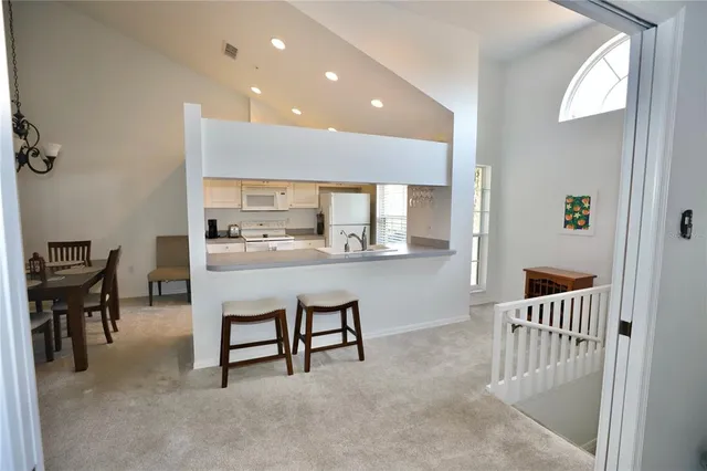 a dining room with furniture and a kitchen view