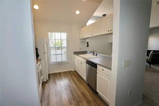 a kitchen with a sink wooden floor and a large window