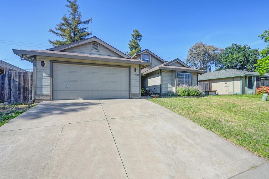 a front view of a house with a garden and yard