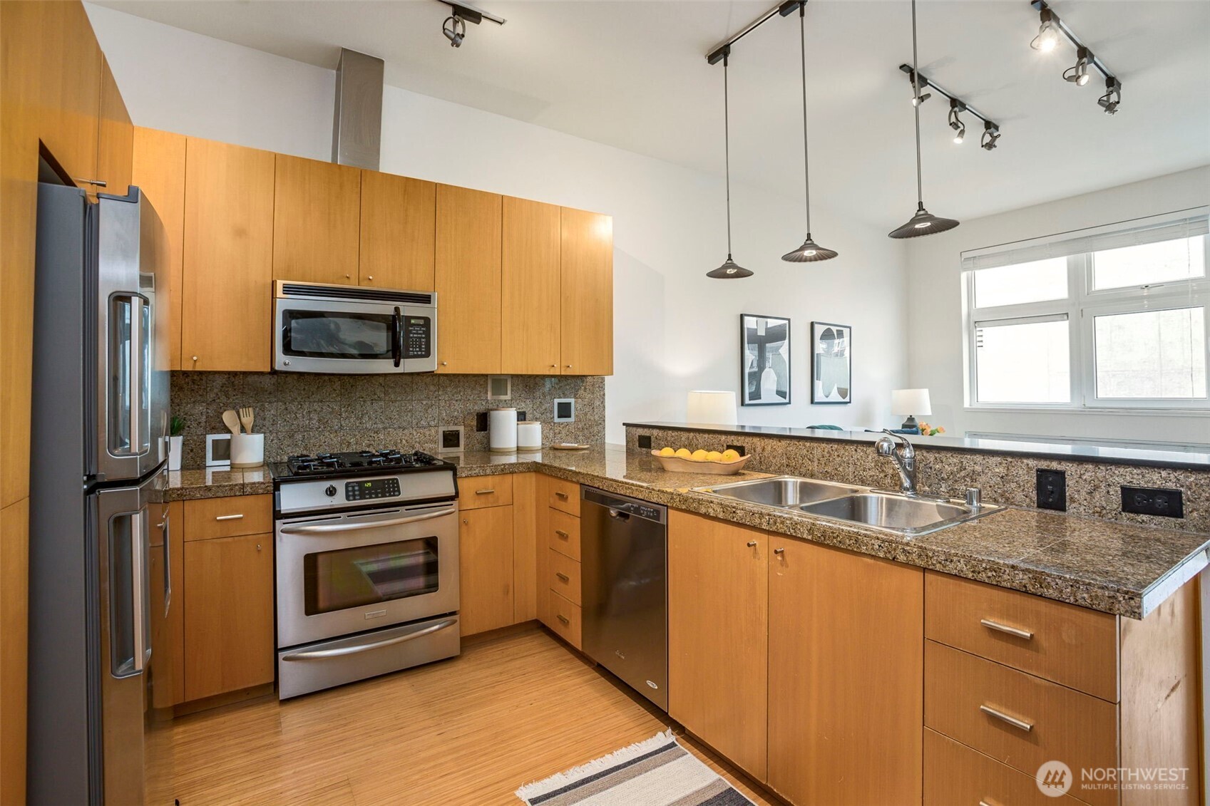 17 West Mercer Street, Unit 218 Seattle, WA 98119 - Photo 8 of 33 a kitchen with stainless steel appliances granite countertop a sink a stove a refrigerator cabinets and a window