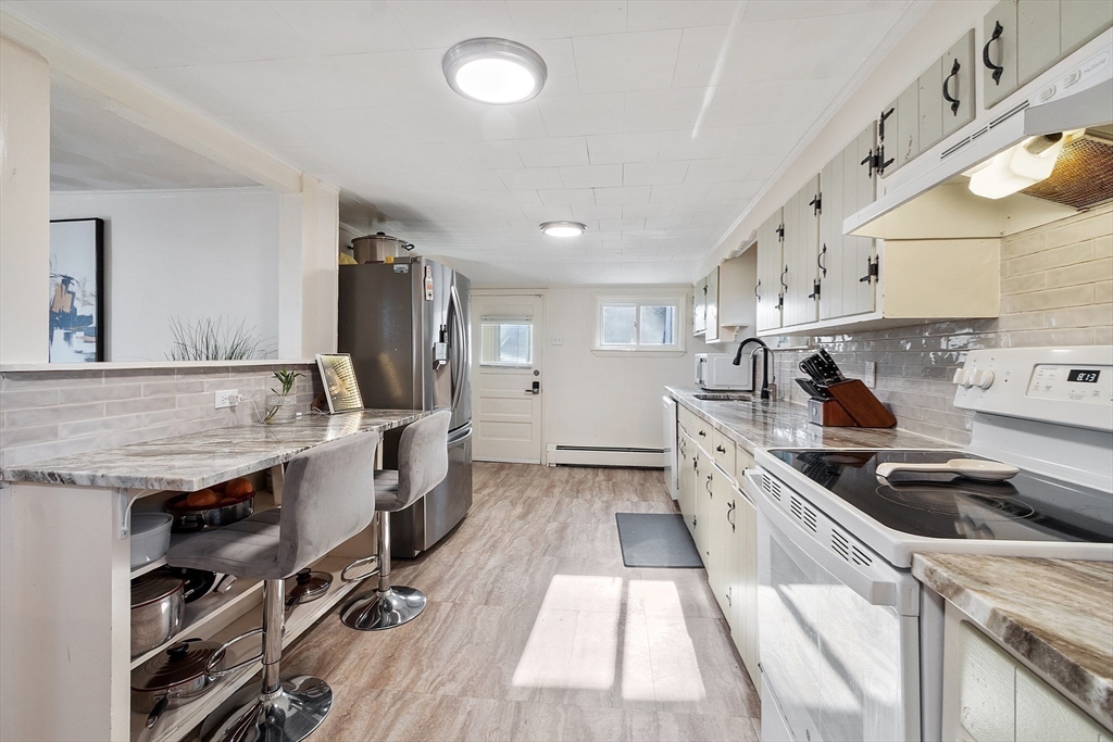 2 Grove Street Methuen, MA 01844 - Photo 13 of 38 a kitchen that has a lot of cabinets in it and wooden floors