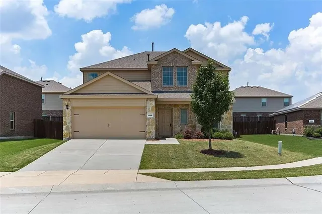 a front view of a house with a yard garage and outdoor seating