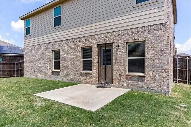 a front view of a house with yard and large tree