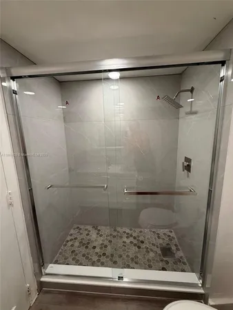 a bathroom with a shower and wooden floor